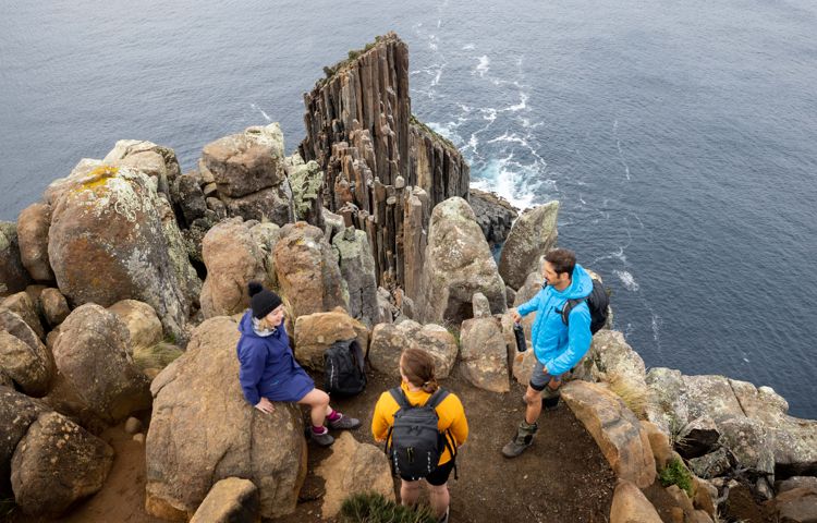 Guests overlooking rocks and cliff at Three Capes