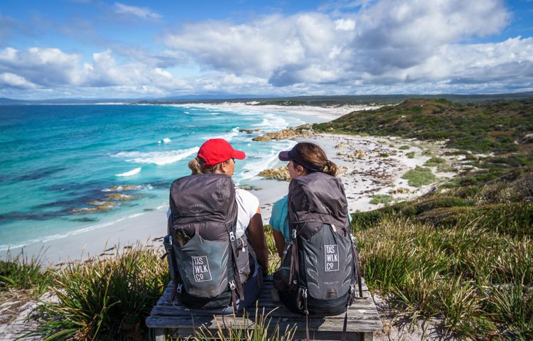 Guests sitting on rocks overlooking beach and ocean